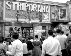 Large crowds at the &lsquo;56 edition of the 'Canadian National Exhibition&rsquo; gather to hear the barker&rsquo;s spiel for the 'STRIPORAMA&rsquo; girlie-revue; featuring top headliner: Jennie Lee.. Toronto mayor Nathan Phillips inadvertently gave treme